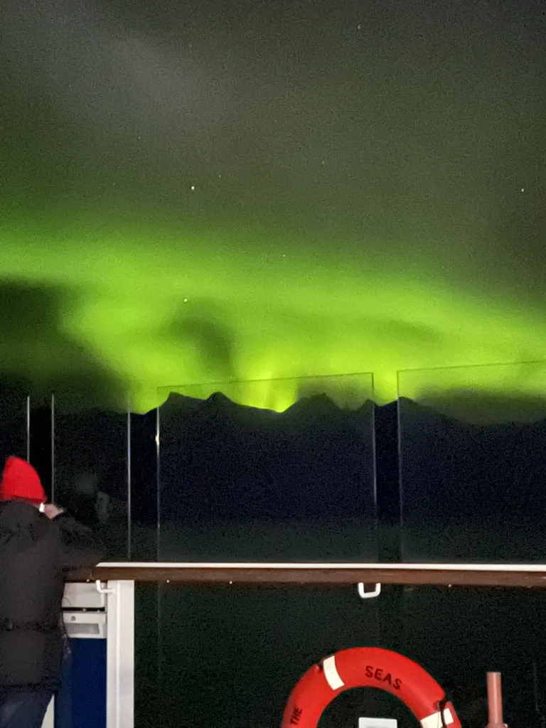 Aurora curtains glowing above the Alaska mountains — Alaska — Aurora Borealis and Inside Passage