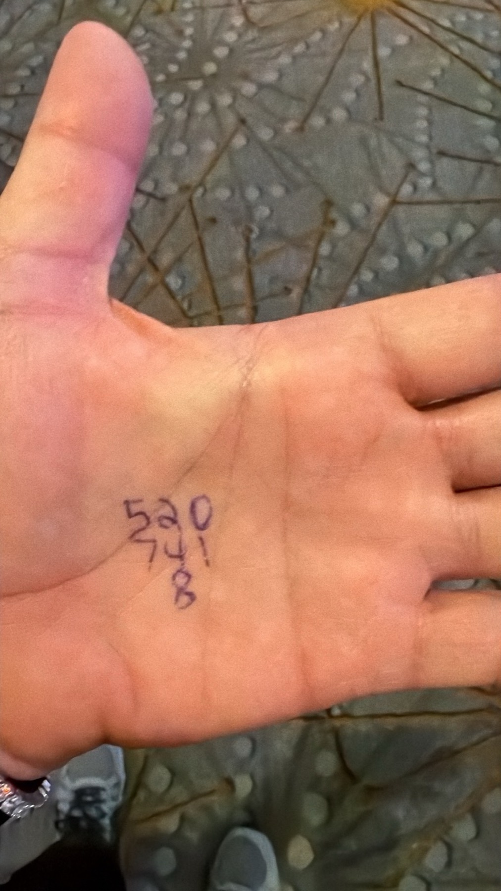 A close-up of a handwritten number ritual on a palm.