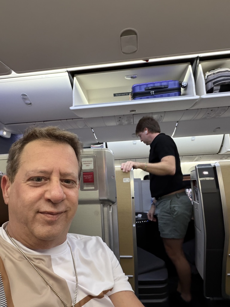 The journey starts before the gangway: Scott A. Astin seated in an airplane cabin before a trip