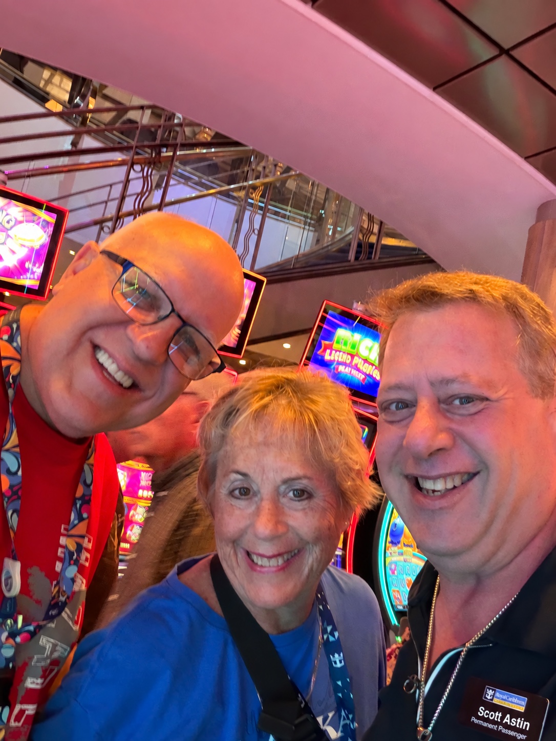 Three smiles, one shipboard memory: Scott A. Astin smiling with two fellow travelers in a brightly lit casino