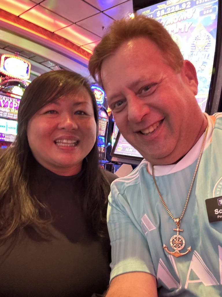 Another night, another story: Scott A. Astin smiling with a fellow traveler beside the casino machines