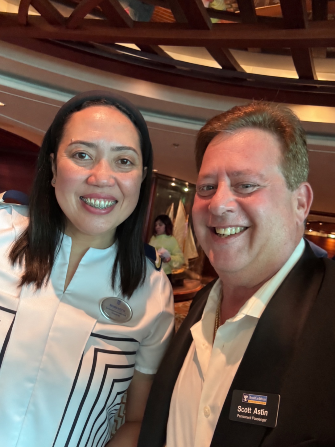 The person behind the welcome: Scott A. Astin smiling beside a dining-room crew member in a white uniform