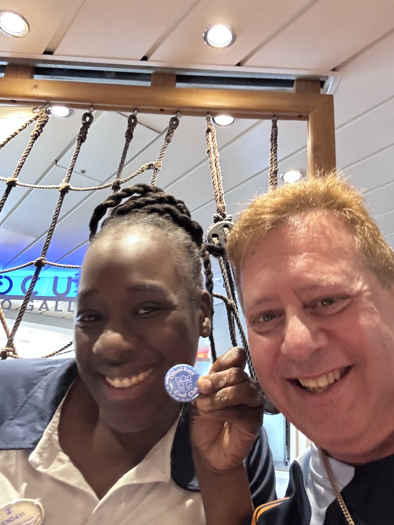 The team behind the voyage: Scott A. Astin beside a uniformed crew member holding a blue keepsake pin