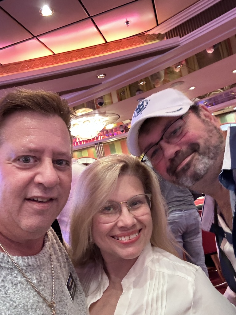 Friends gathered for one more picture: Scott A. Astin smiling with two fellow travelers in the casino