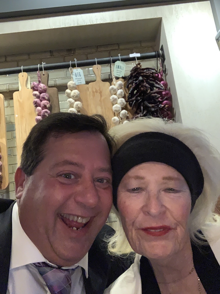 A familiar face far from home: Scott A. Astin smiling with a fellow traveler inside a shop