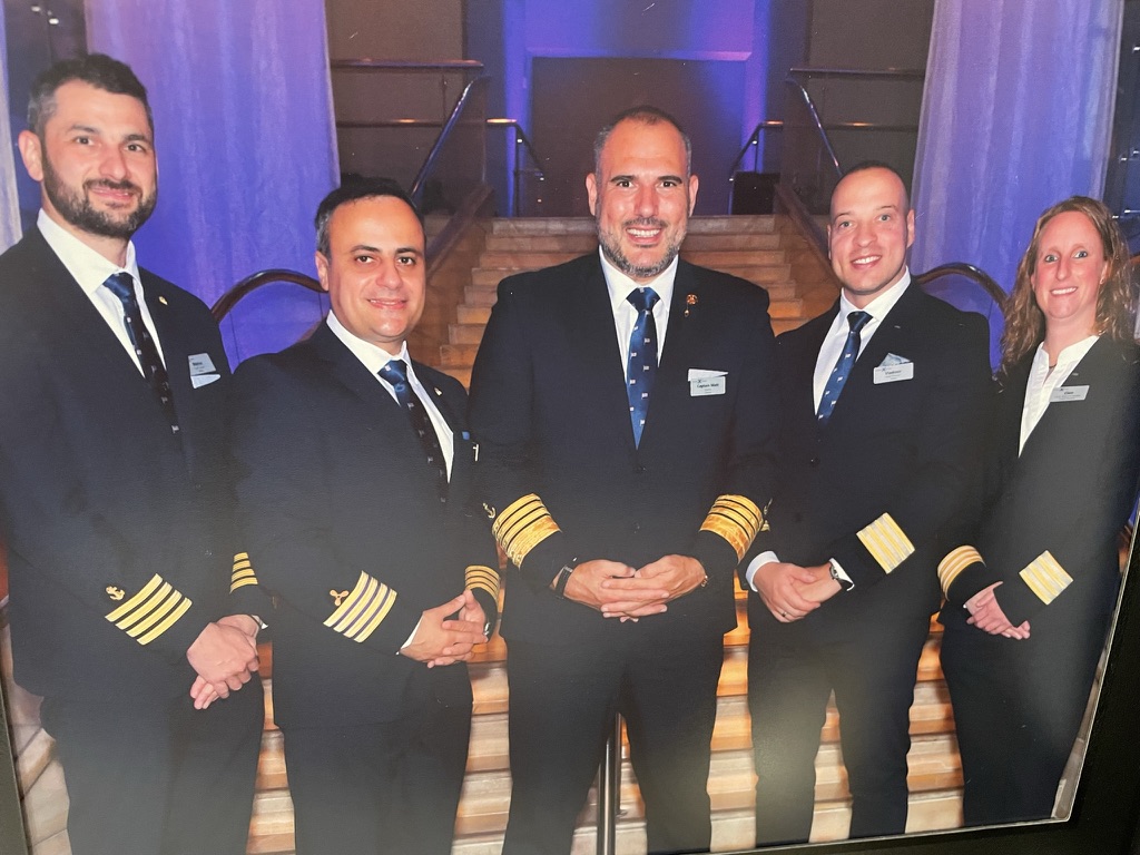 Five senior ship officers gathered on the grand staircase